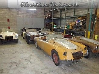 A collection of mga&#039;s 5 rolling cars and 3 chassis as well as many spare parts