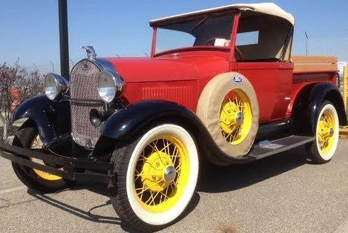 Red 1929 model a roadster pickup, black fenders with oak wooden planks in bed!