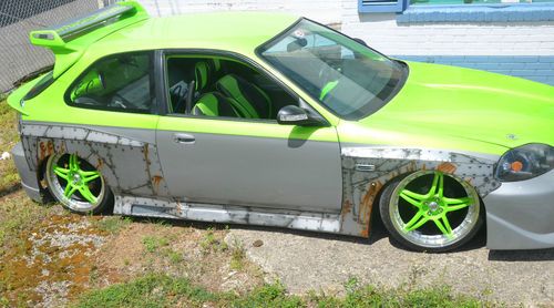 Green, custom widebody hatchback, airbrushed graphics, air ride and airhorns.