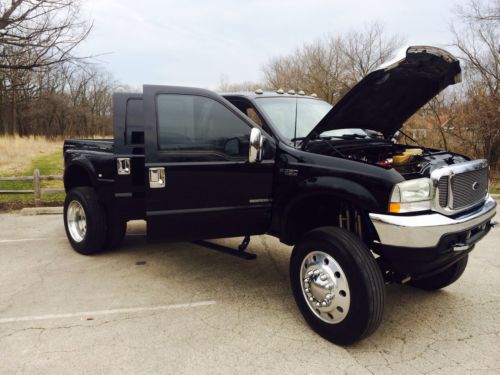 Black ford lifted dually super duty monster truck show truck on semi tires