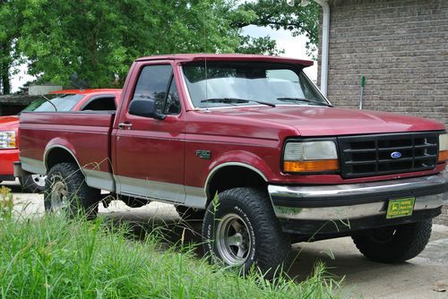 Maroon ford f-150 2 wheel drive truck. has six inch lift.