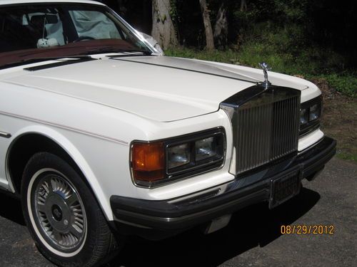White rolls royce silver spirit with red leather.