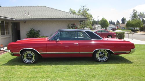 Cutlass h/t, black over red, floor shift console auto, black velour/vinyl int.