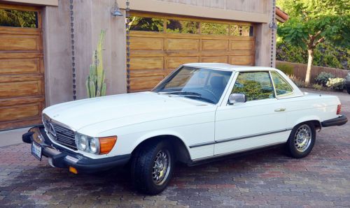 White convertible with two tops, soft top is blue, interior is blue leather