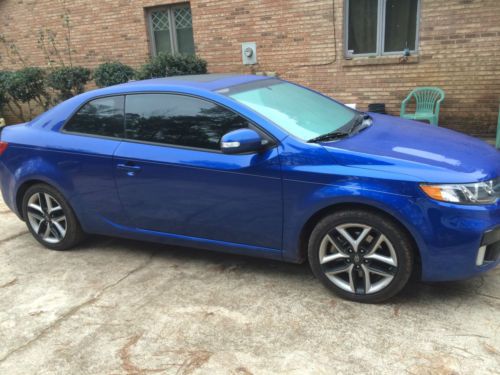 2010 kia forte koup. 2 door blue with black rims. led halo headlights