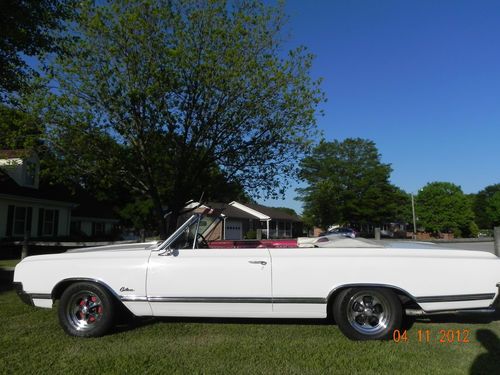 1965 olds cutlass f85 convertible / white with red interior and red top.