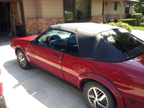 Convertible, red body, newer black top, two door, 2.0 liter turbo, racing seats