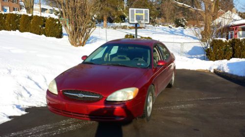Very nice ford taurus sedan, red with grey interior.  low miles for year one own