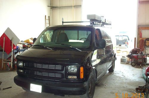 A black chevy work van very dependable with ladder racks and shelving in back