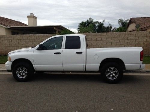 White quad cab, black interior, oversized tires with tow package
